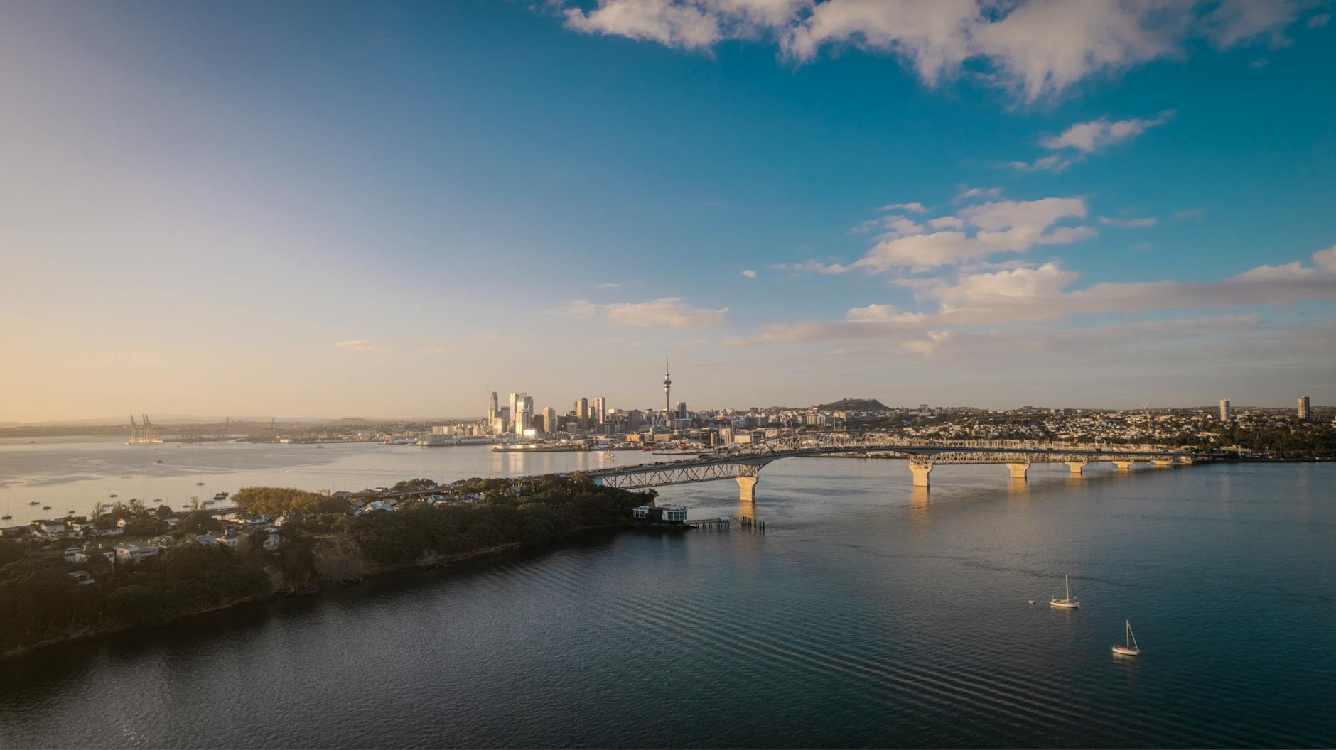 Panorama Auckland z mostem Harbour Bridge o zachodzie słońca