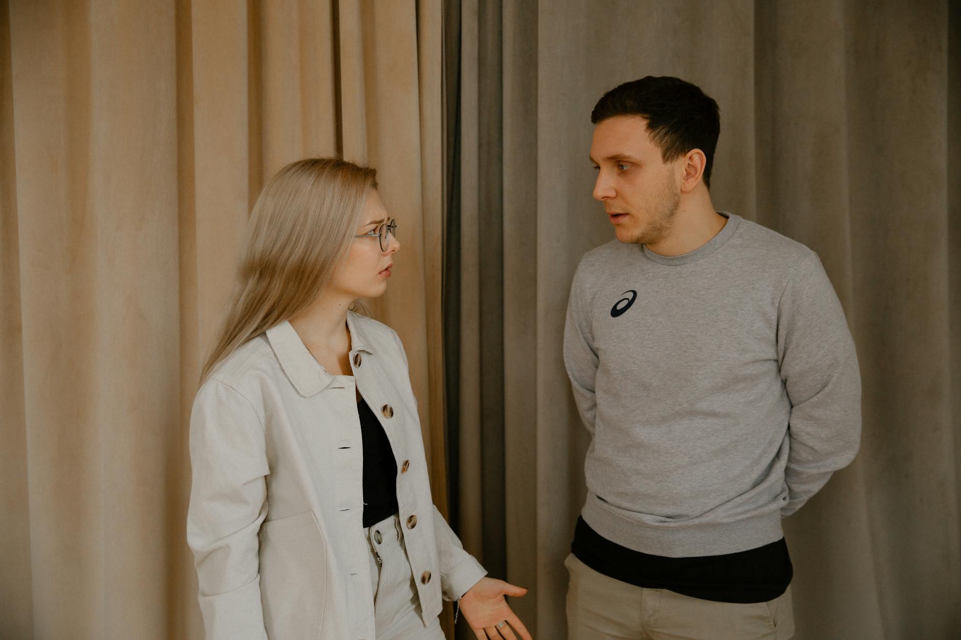 Para w mieszkaniu rozmawia poważnie, patrząc na siebie uważnie
